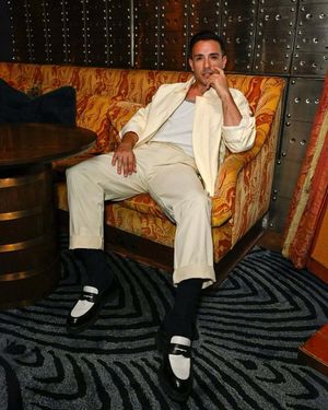 Ivory Bomber Jacket with White Tank Top and Pleated Trousers